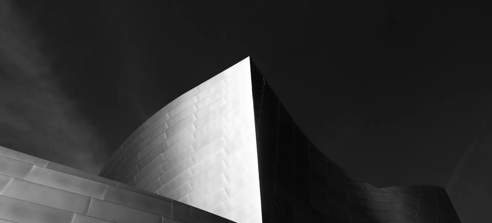 Curved metal architecture against a dark sky